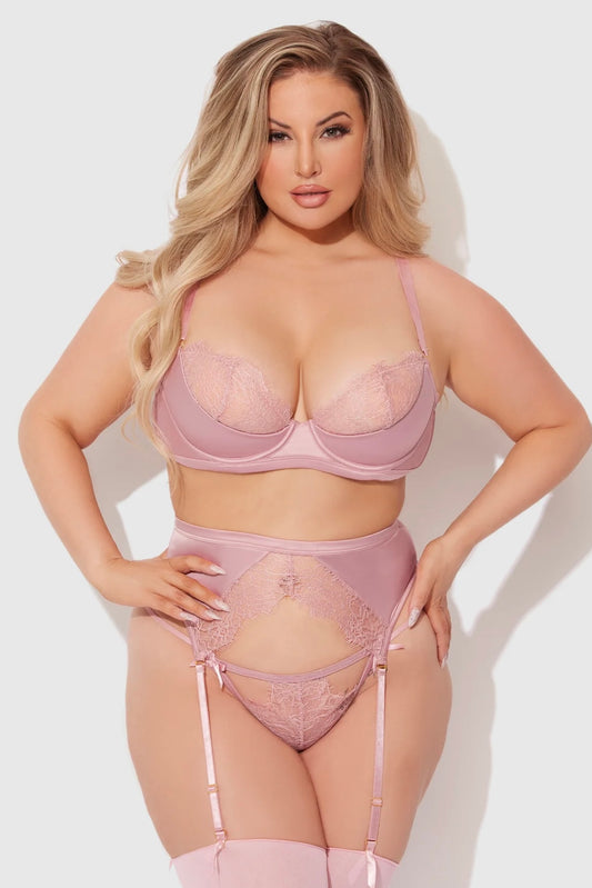 Woman wearing a pink lingerie set against a white background